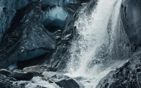 water rushes down a rocky waterfall